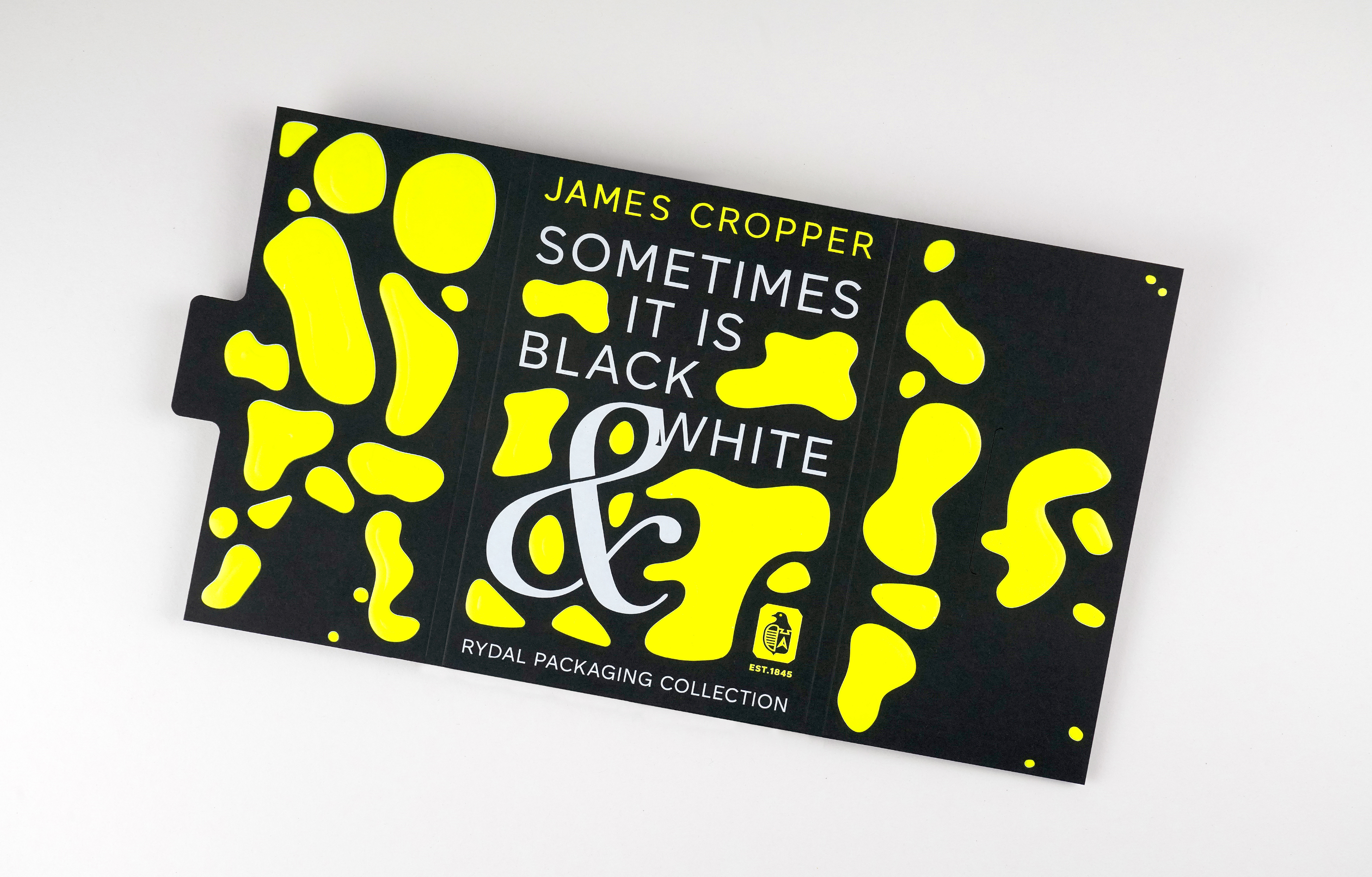 A printed sample pack with the title 'Sometimes it is Black & White'. White foil on black paper stock, with neon yellow topography design detail.